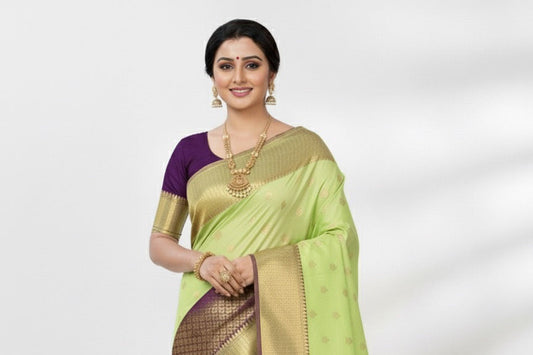 Woman wearing a light green saree with a purple blouse on a white background